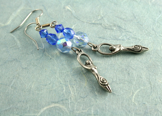 Blue crystal birth goddess earrings on blue, med